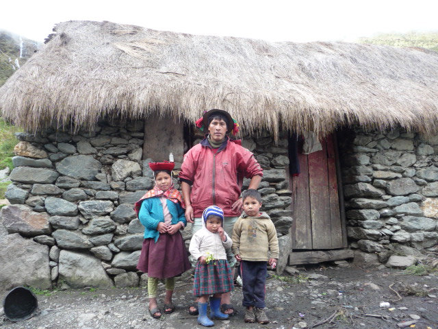 A family from the high Andean community of Panticalle, poses in front of their house